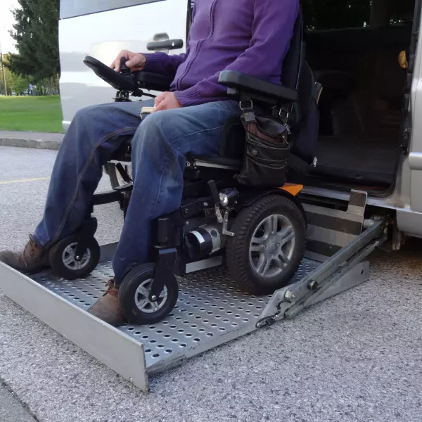 Man sitting in wheelchair on disability ramp for van