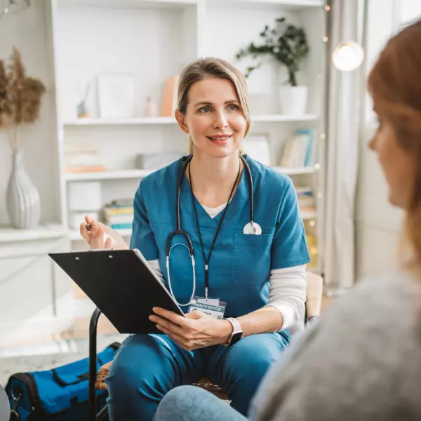 Community nurse in home smiling with participant